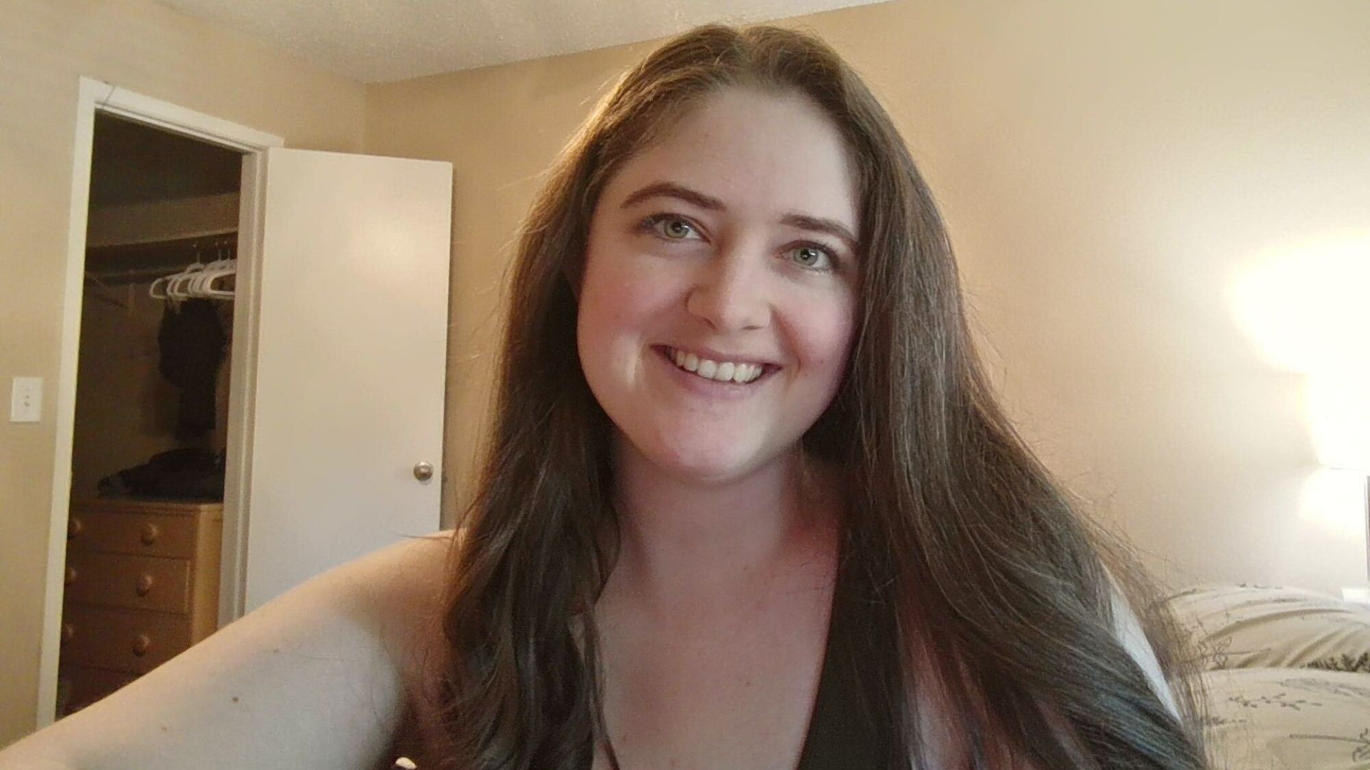 a webcam selfie of the author, a woman with long brown hair and green eyes