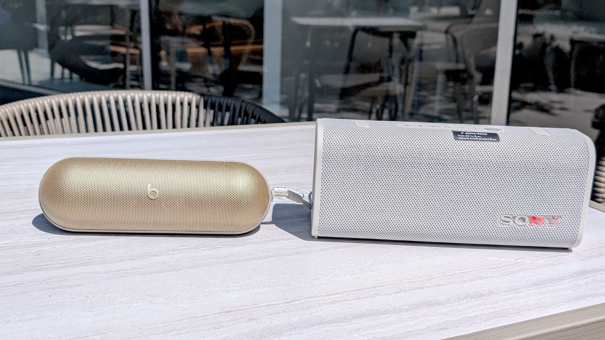 beats pill and sony ult field 3 side by side on outdoor table