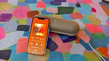 beats pill speaker with phone open to spotify app