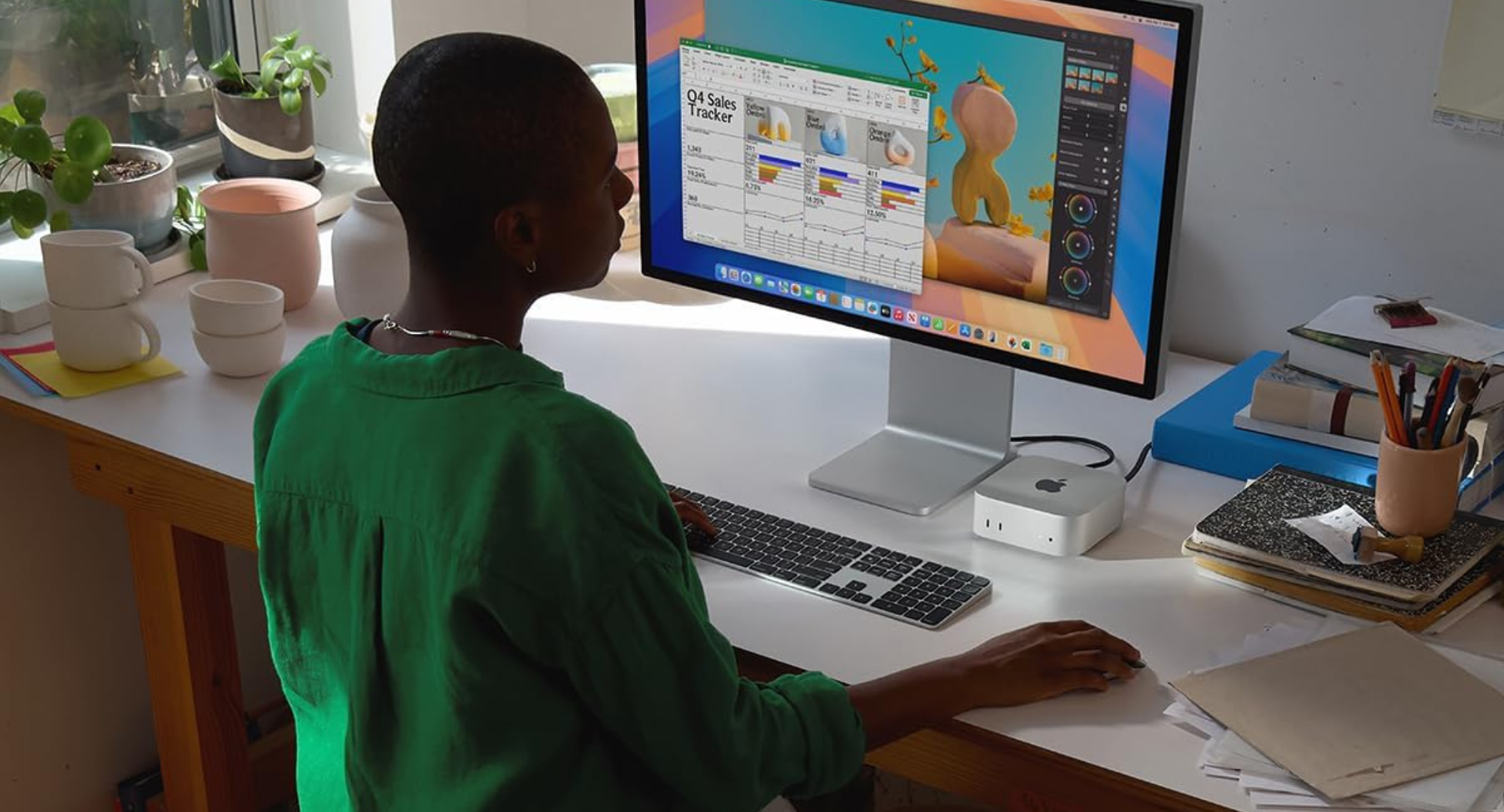 A person sitting at a desk using their M4 Mac Mini desktop computer. 