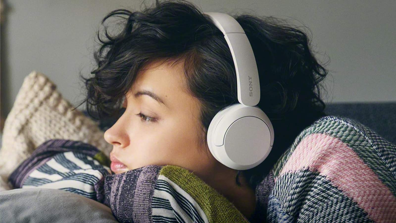 dark haired woman wearing Sony Wh-Ch520 headphones in white