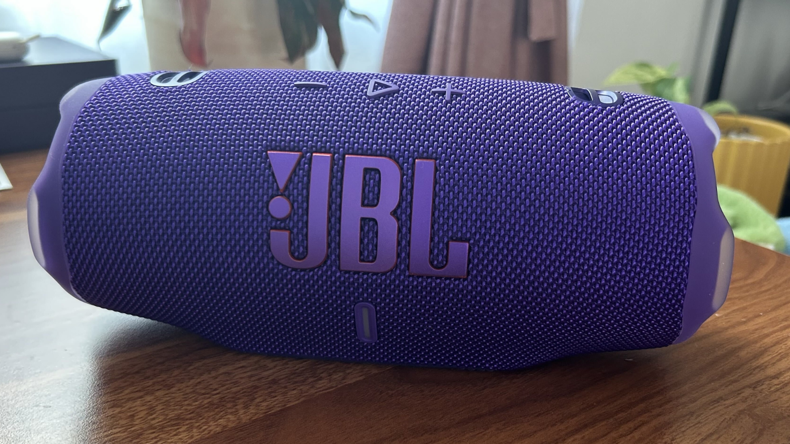  a purple jbl charge 6 on a wooden table
