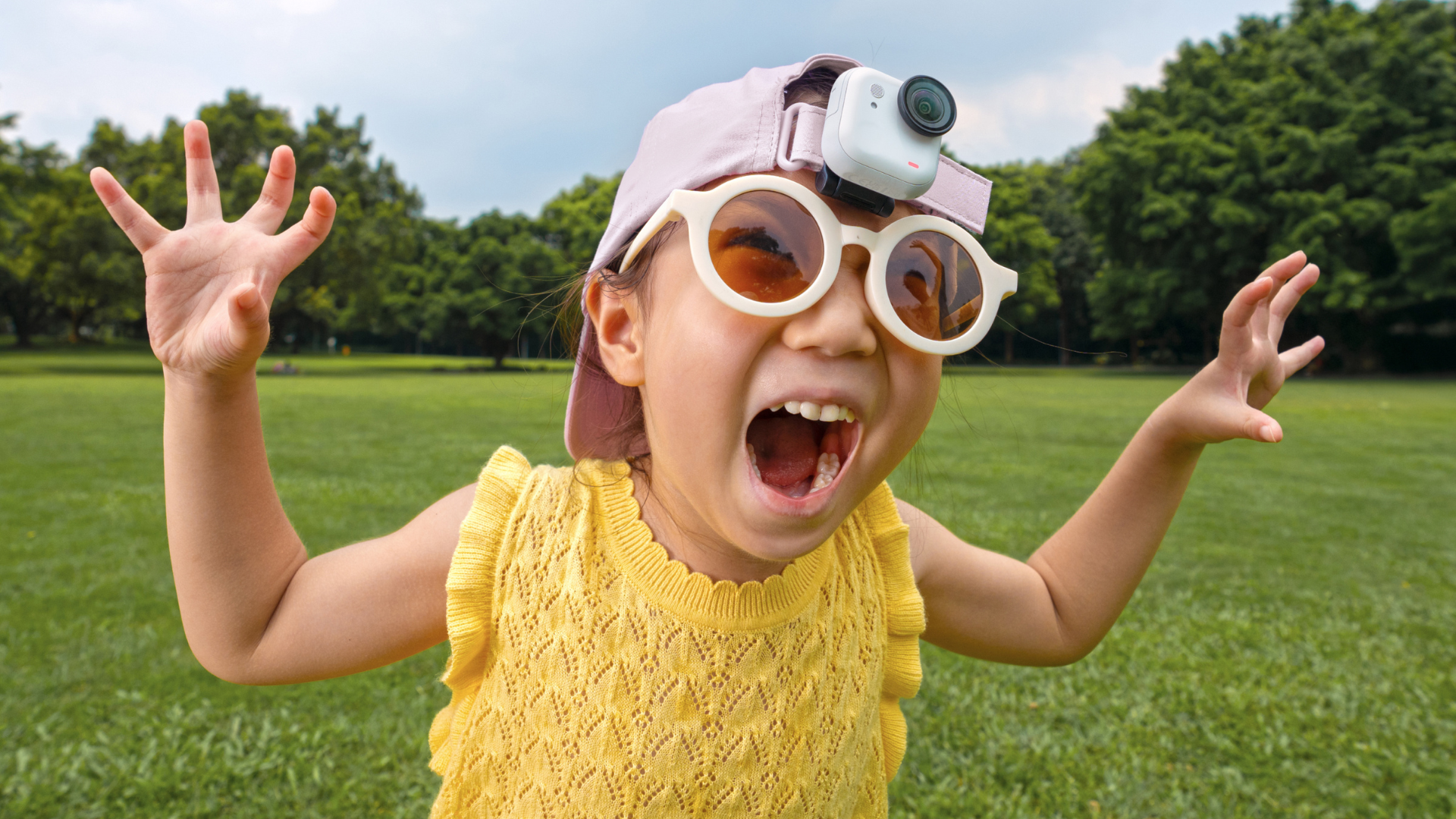 A white Insta360 GO Ultra attached to a cap being worn by a young child.