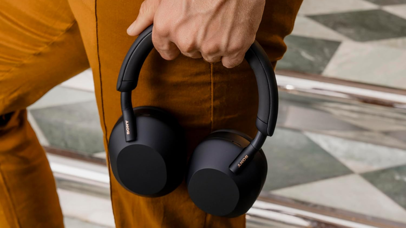 close up of person carrying Sony WH-1000XM5 headphones