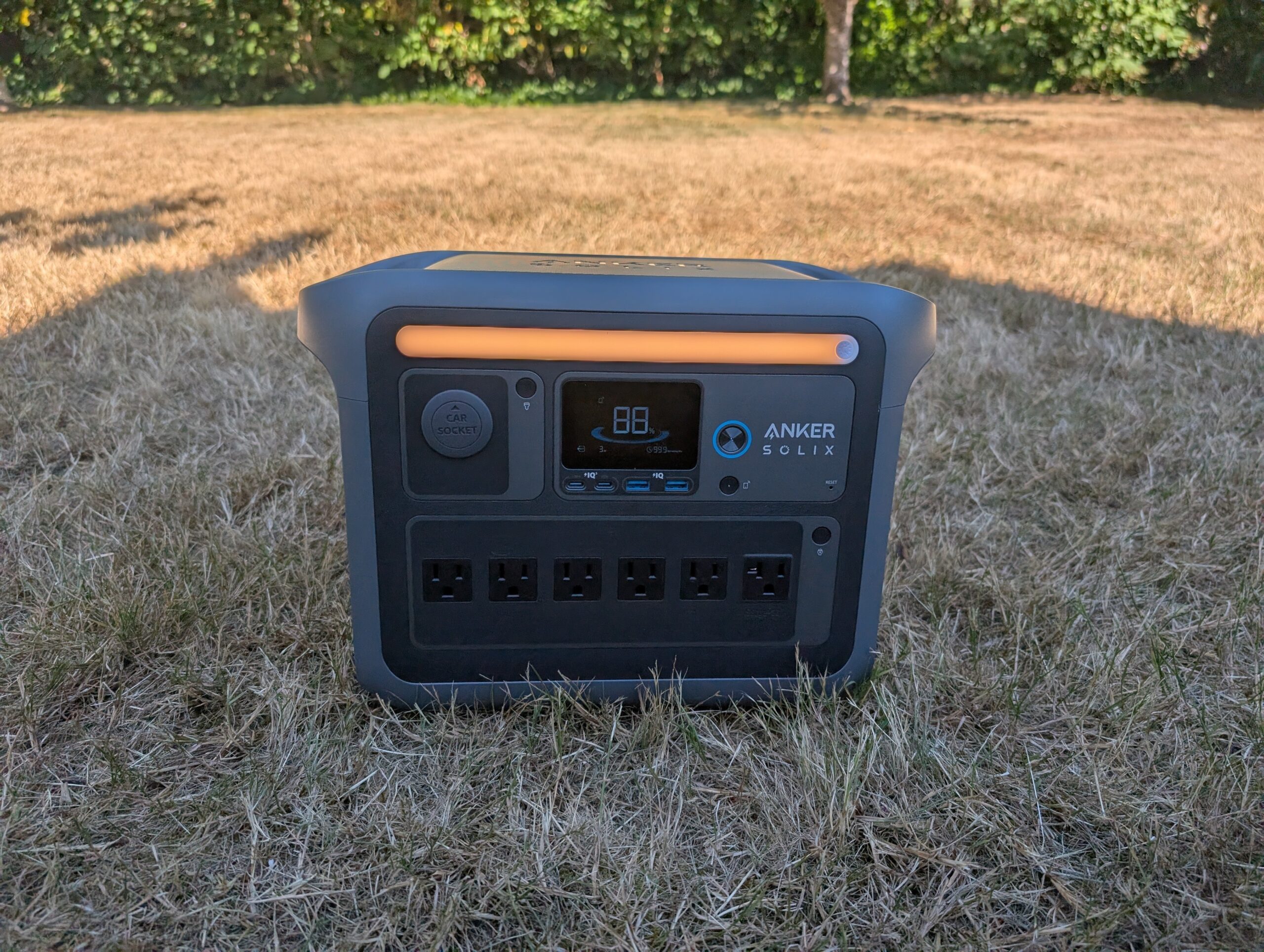 the anker solix c1000 portable power station on brown grass in a backyard
