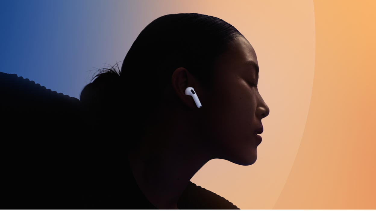 woman wearing Apple AirPods 4 with colorful backdrop