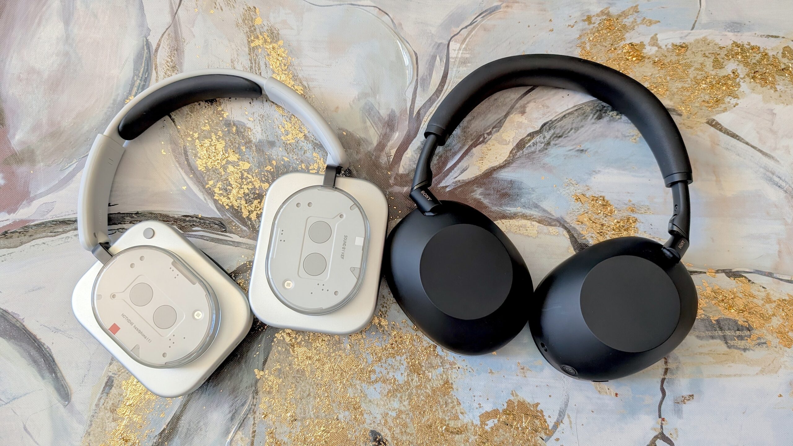 nothing headphone (1) next to SOny xm6 headphones on marble