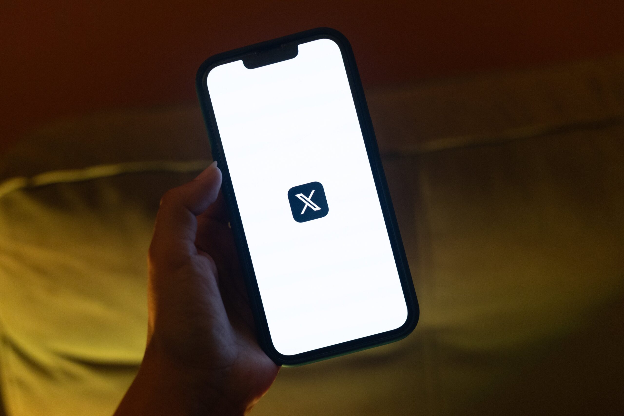 The logo of X, the social media platform formerly known as Twitter, displayed on a smartphone