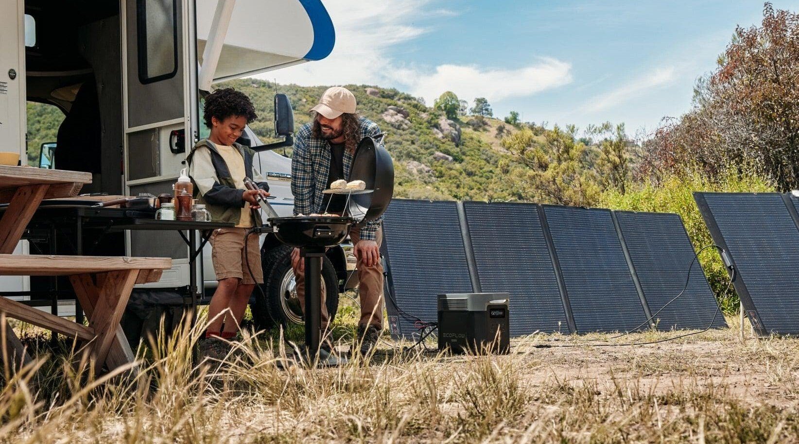 the ecoflow delta 2 max with solar panels set up in a grassy area near an RV