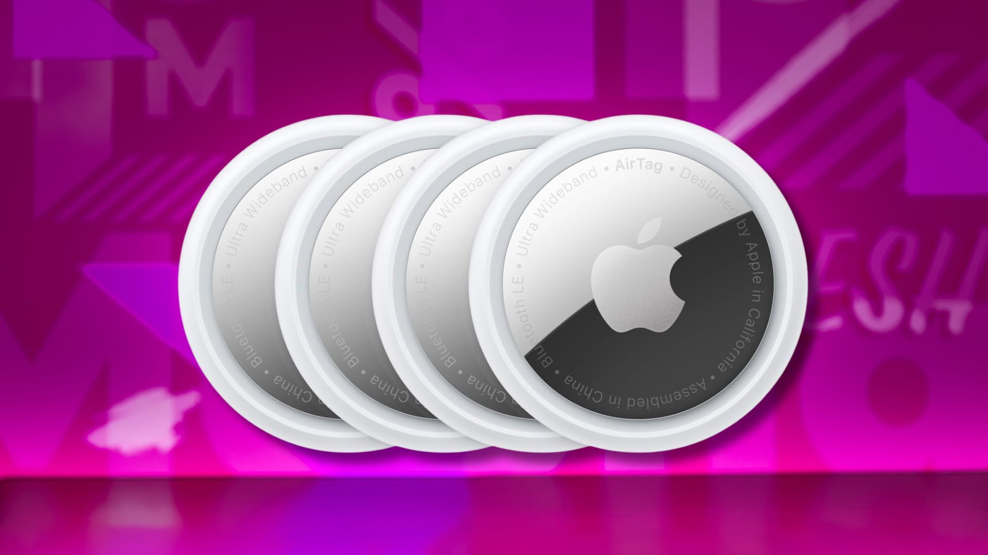 four pack of apple airtags against a pink patterned background