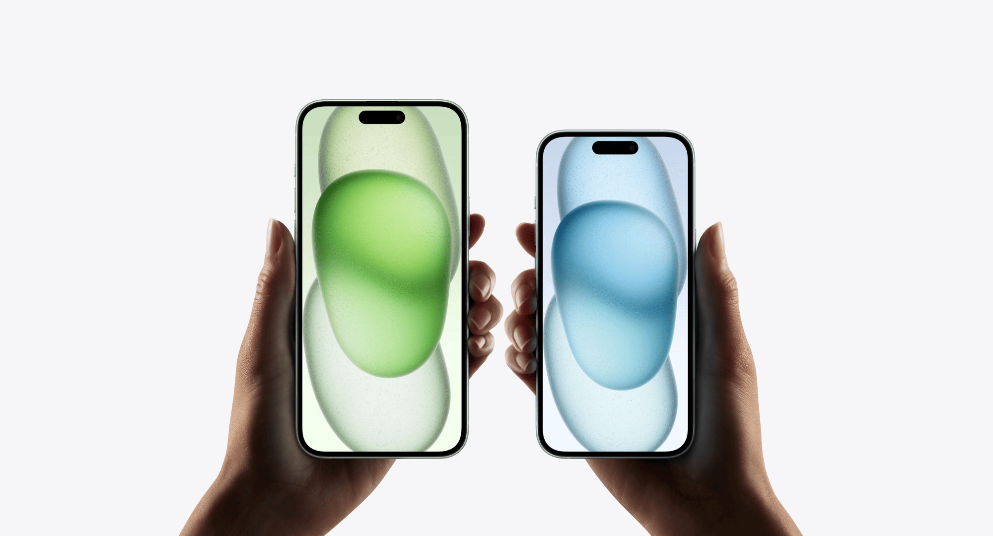 Two hands holding up iPhones against a gray background.