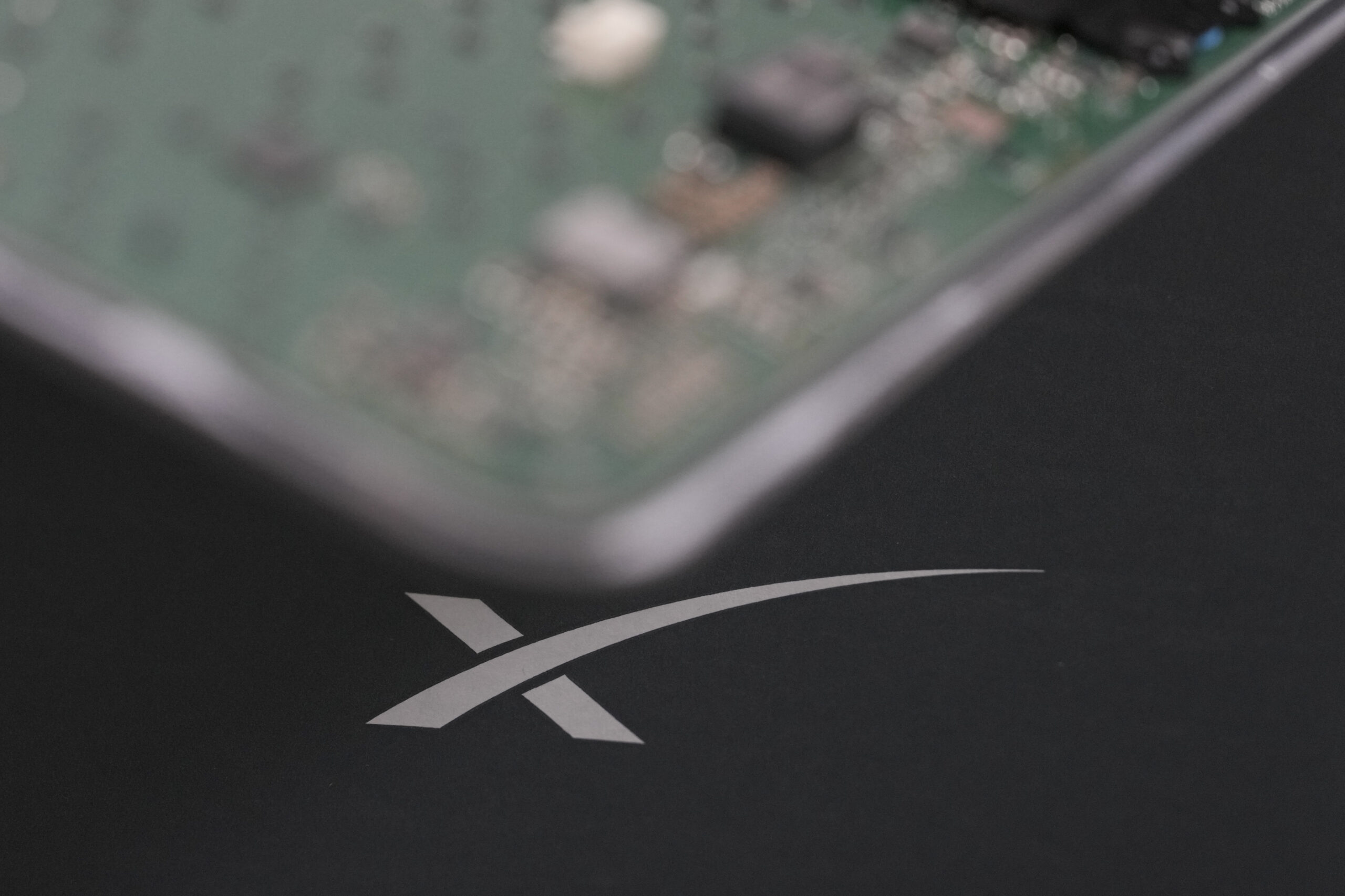A blurry Starlink terminal board with the SpaceX logo behind.