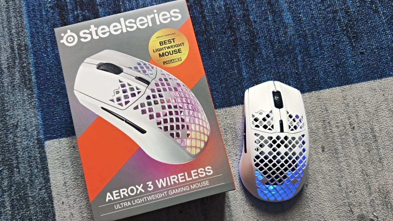 The SteelSeries Aerox 3 Wireless gaming mouse and its box on a blue background