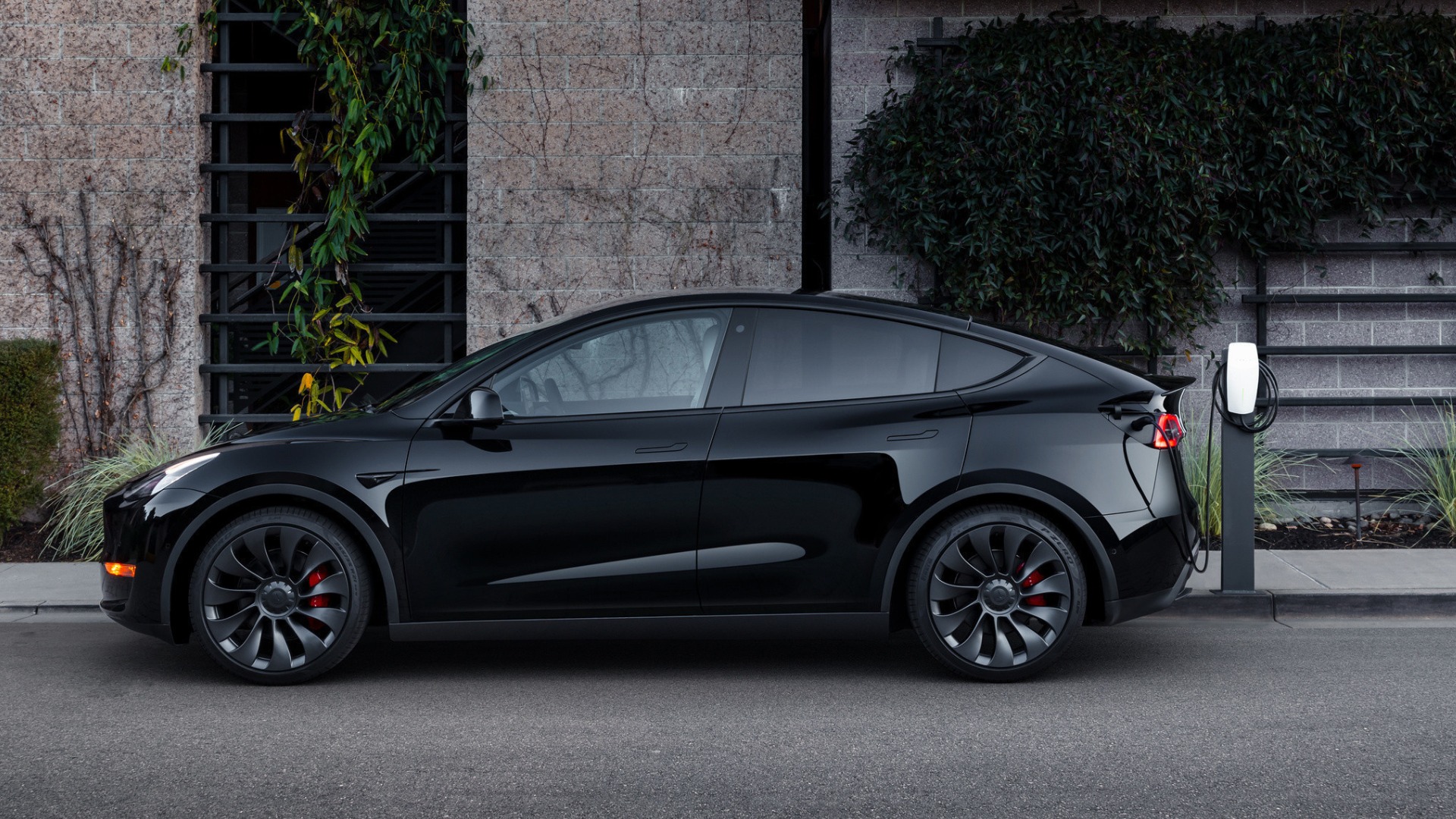 A black Tesla Model Y, parked on a street.