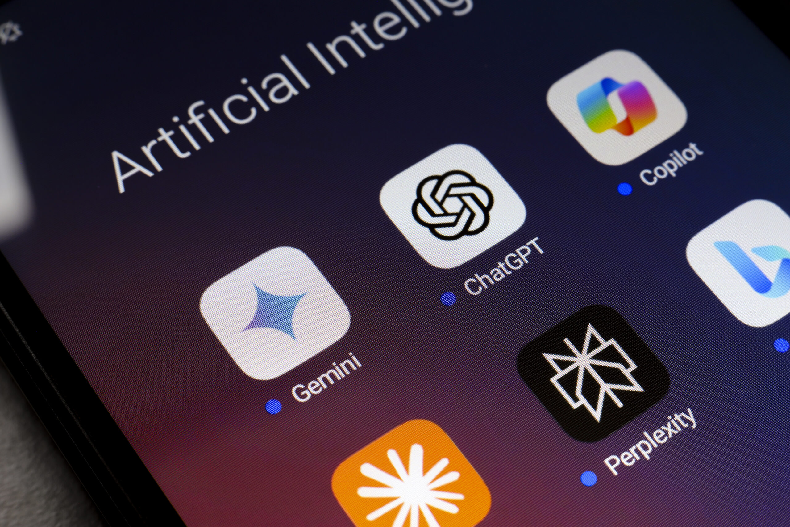 A phone shows a folder of AI apps. 