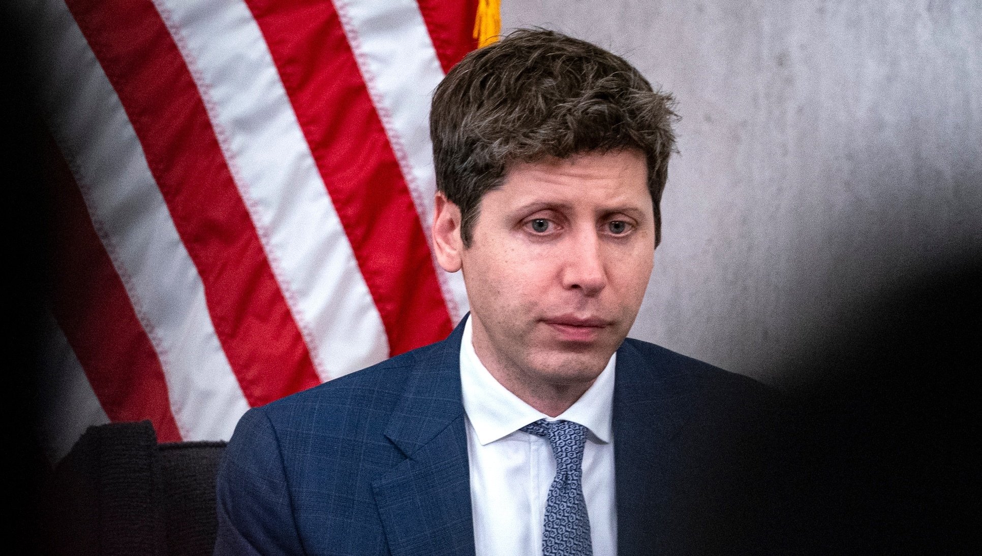 Sam Altman looks despondent in front of an American flag