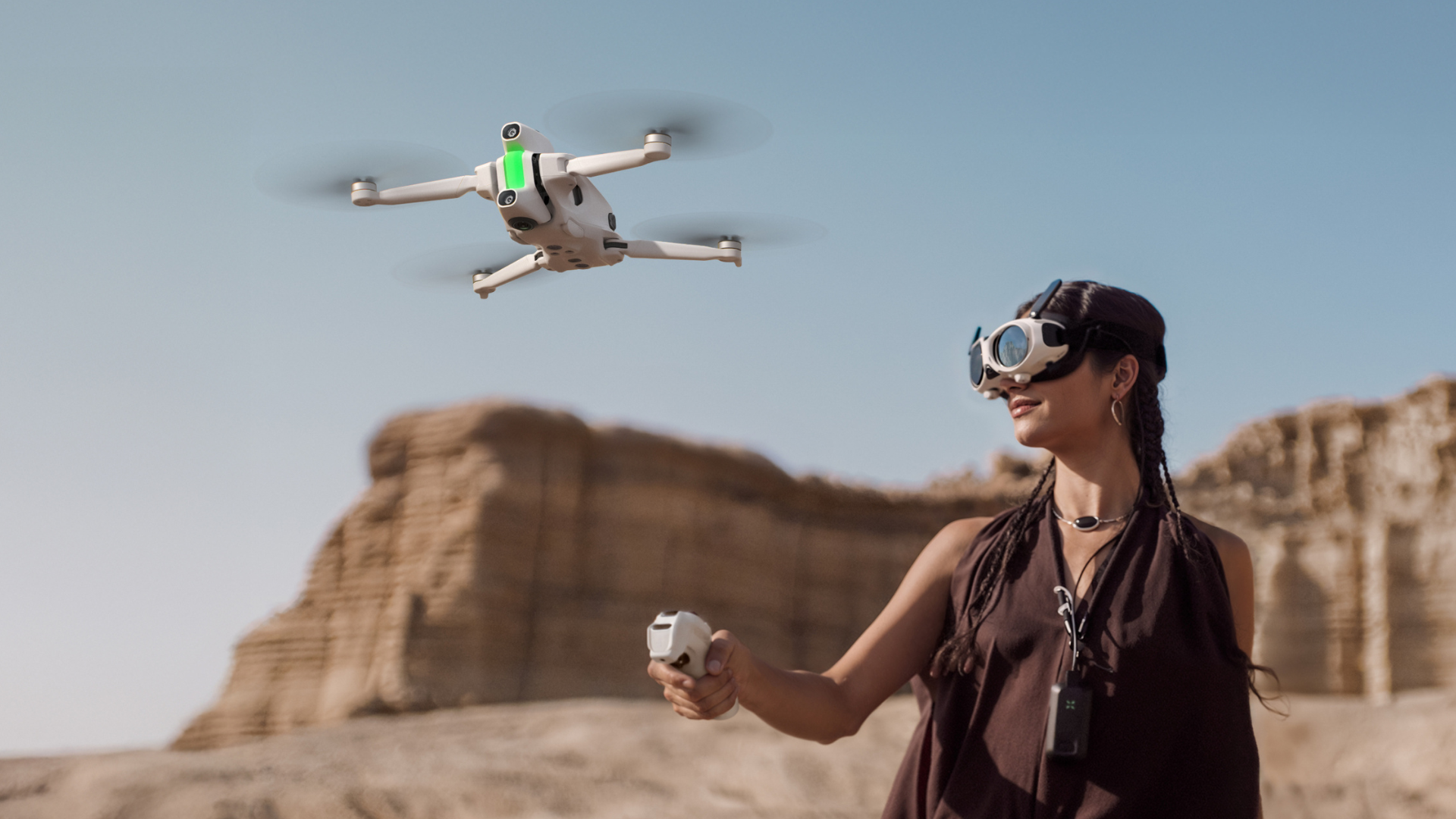 A woman flying the Antigravity A1 drone, wearing the Vision goggles and holding the Grip controller.