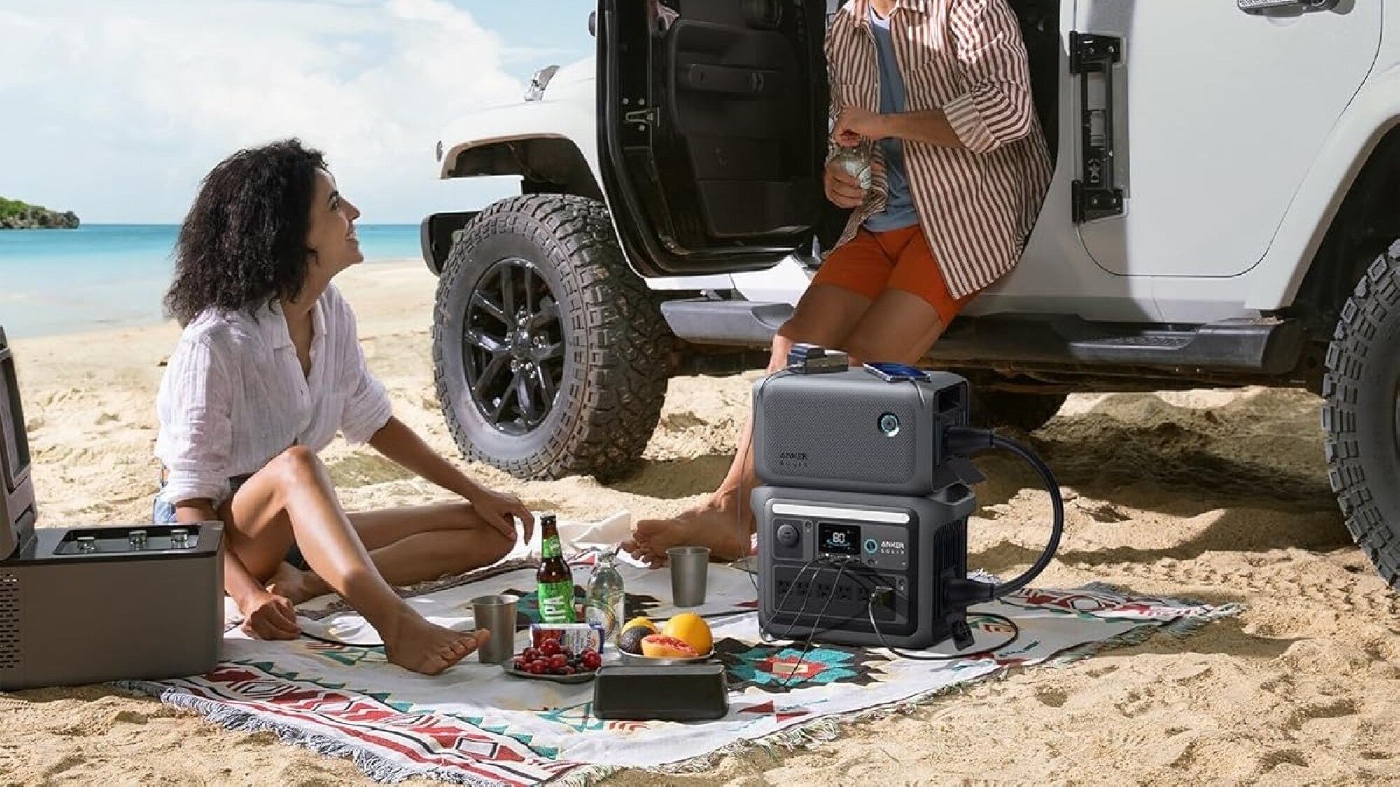 the anker solix c1000 portable power station on the beach with its expandable battery above it