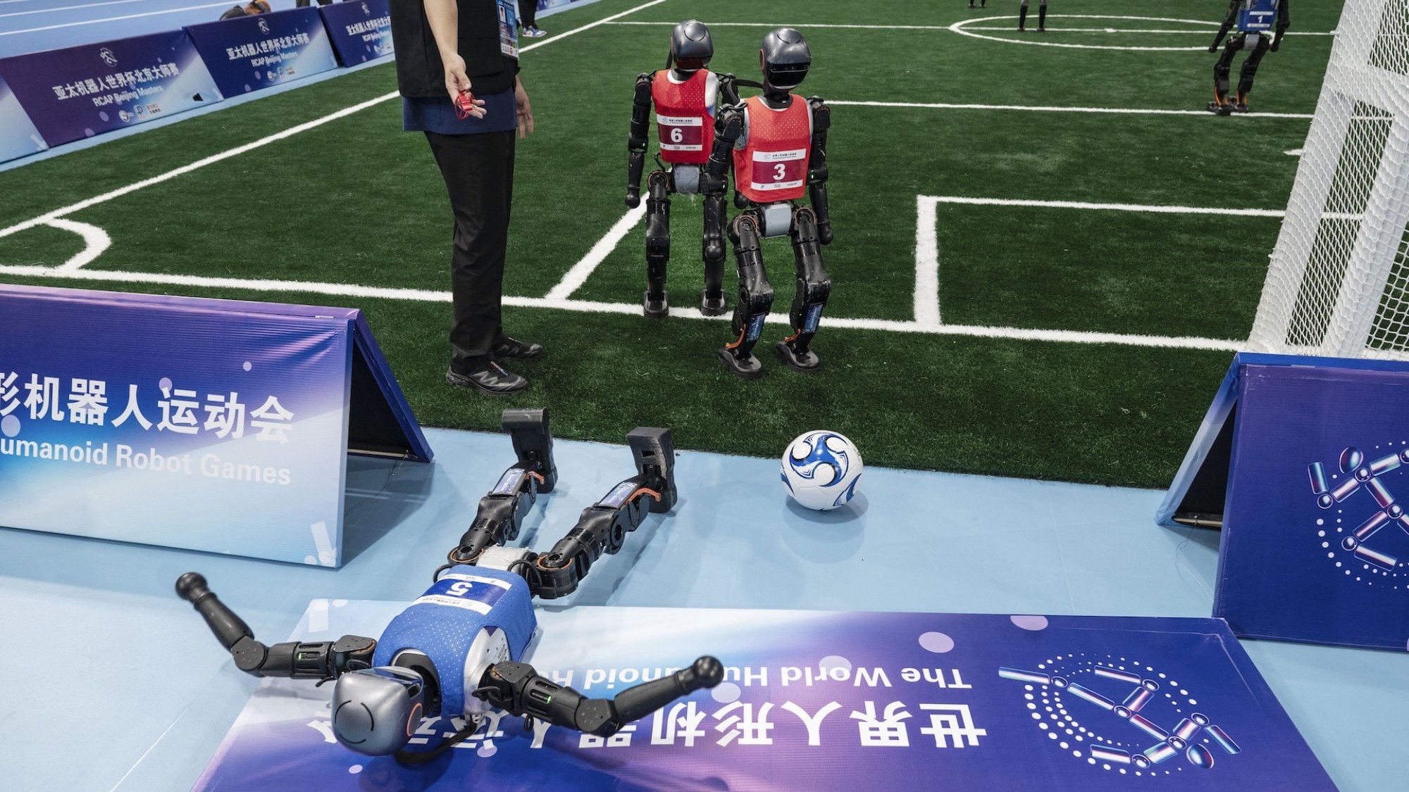Robots play football at the 2025 World Humanoid Robot Games.