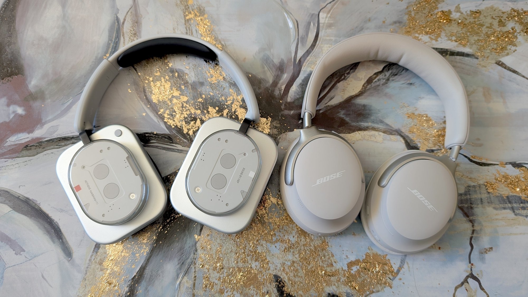 nothing headphones next to bose quietcomfort ultra headphones on marble counter