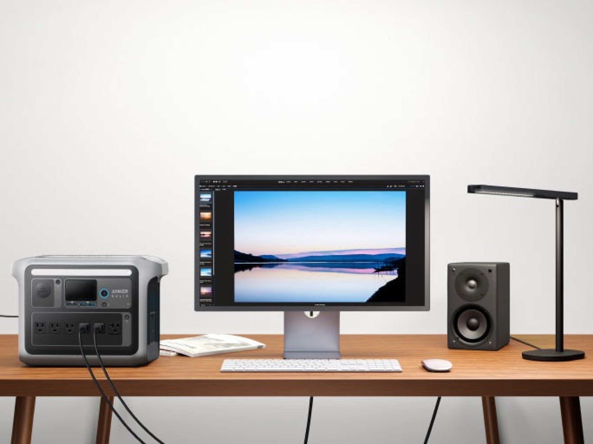 the anker solix c1000 on a desk powering a laptop, speaker, and lamp