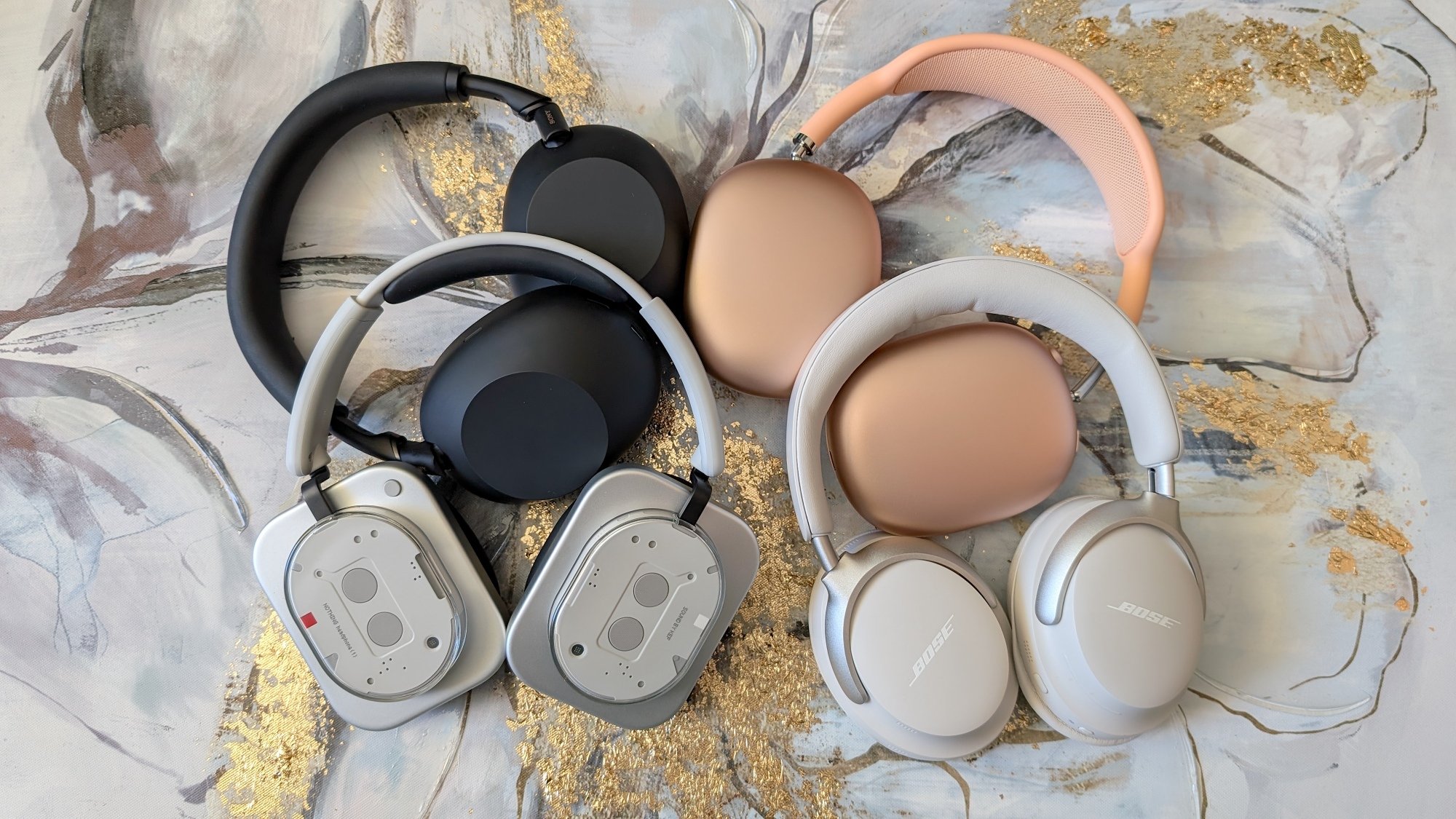 nothing, bose, sony, and apple headphones on a marble countertop