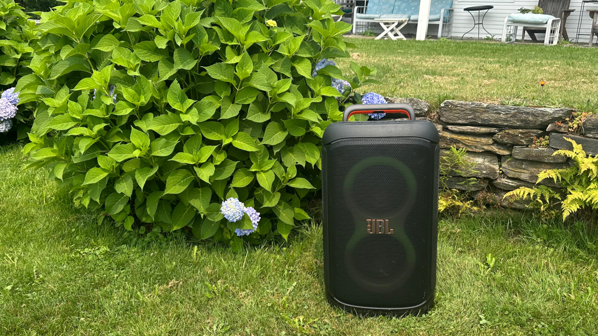 A JBL PartyBox 520 in an outdoor garden.