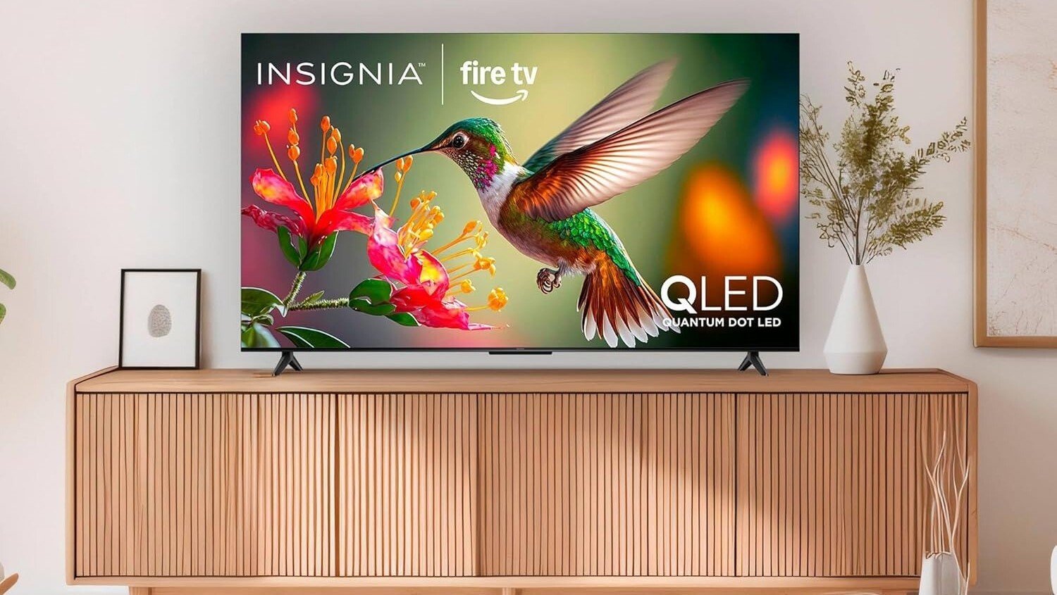 the 65-inch Insignia class qf series TV in a living room, sitting on an entertainment center