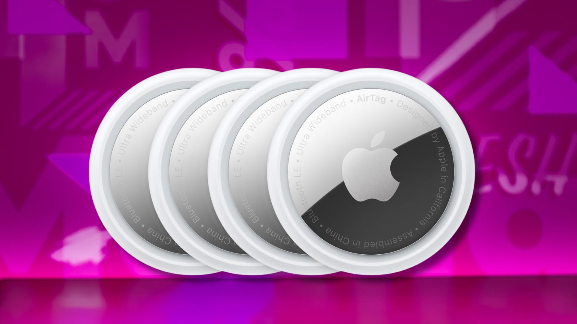four pack of apple airtags against a pink patterned background