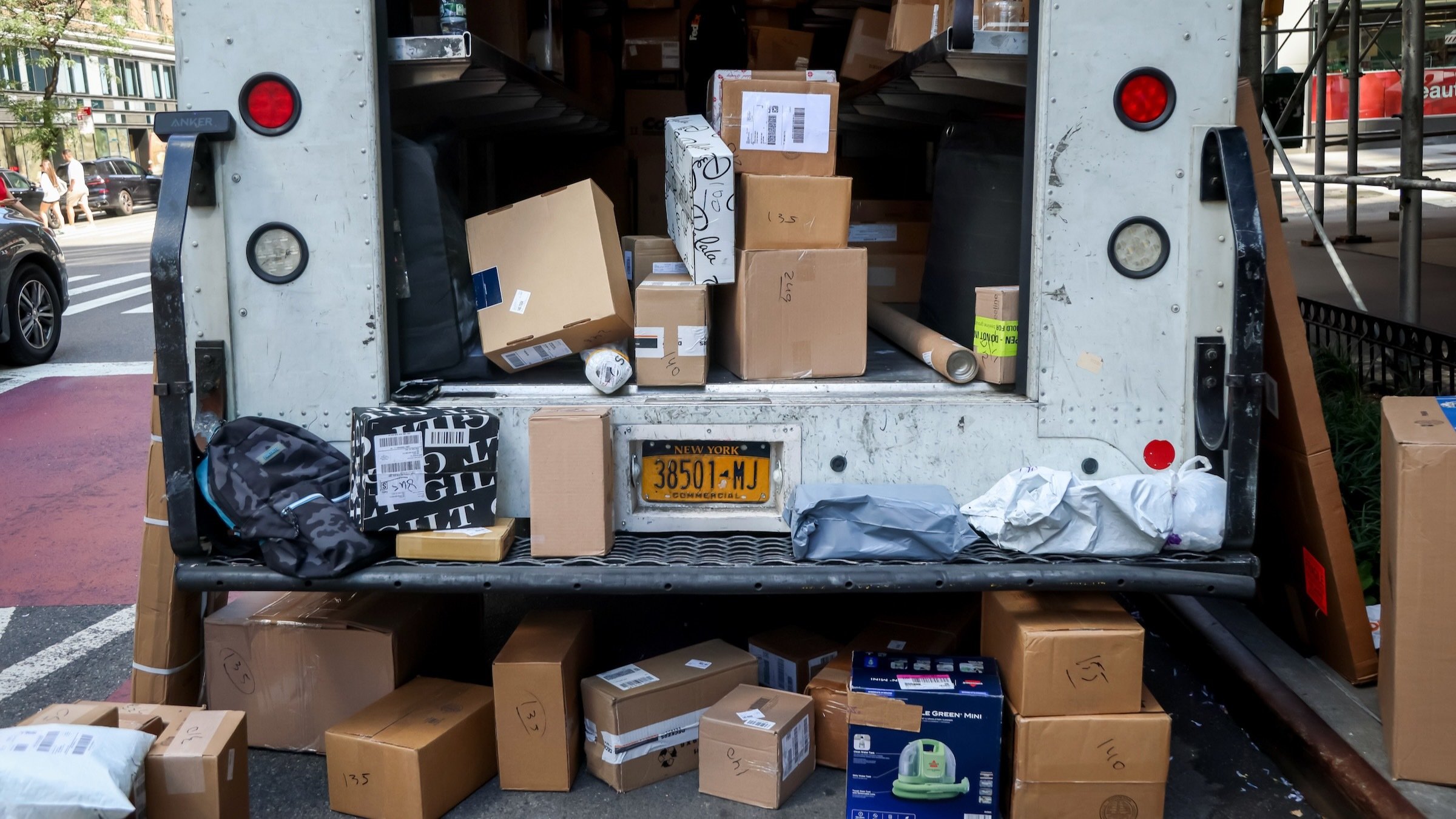 the back of a usps truck is crowded with online package deliveries