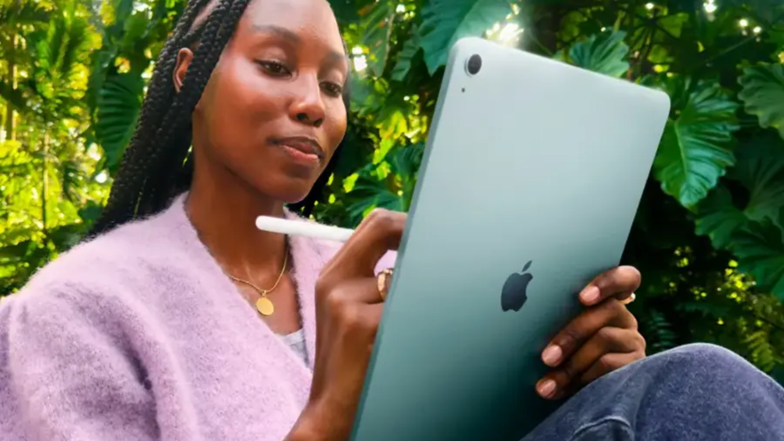 a woman writing on the m3 apple ipad air using a stylus