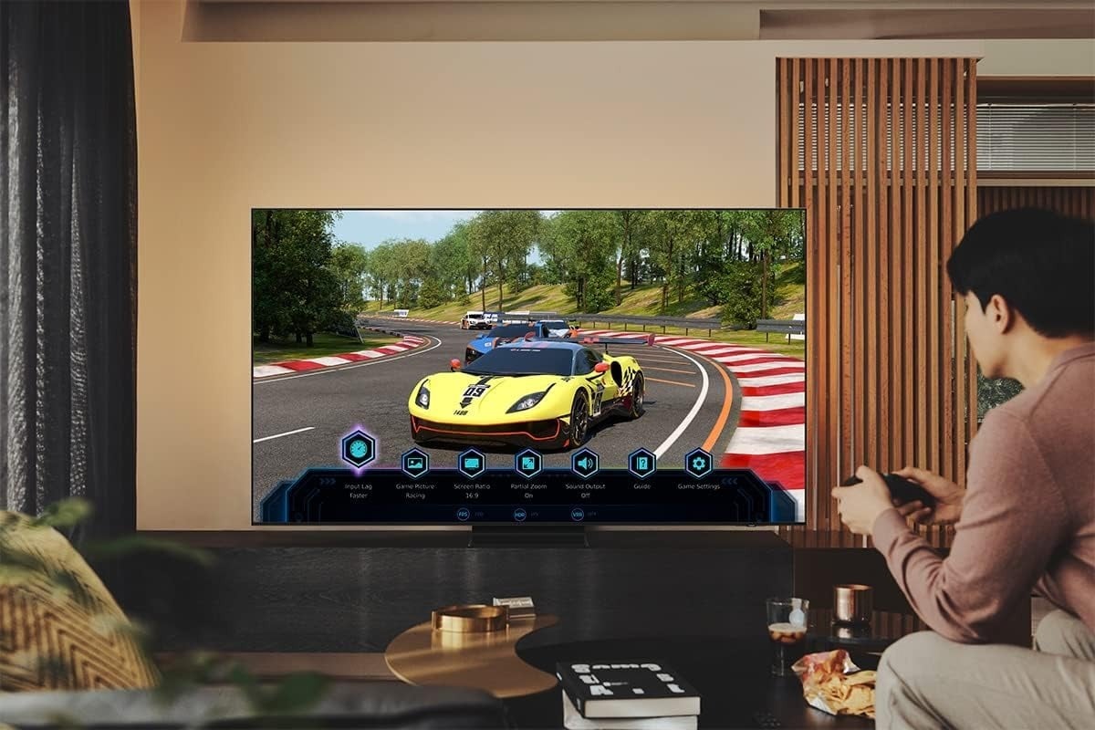 a person plays a video game on the 85-inch Samsung Class Neo QLED tv that's in a living room.