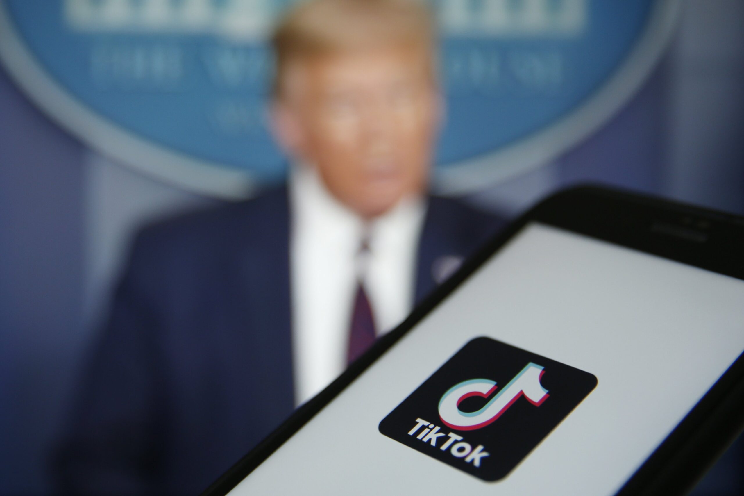 TikTok logo on mobile device and Donald Trump