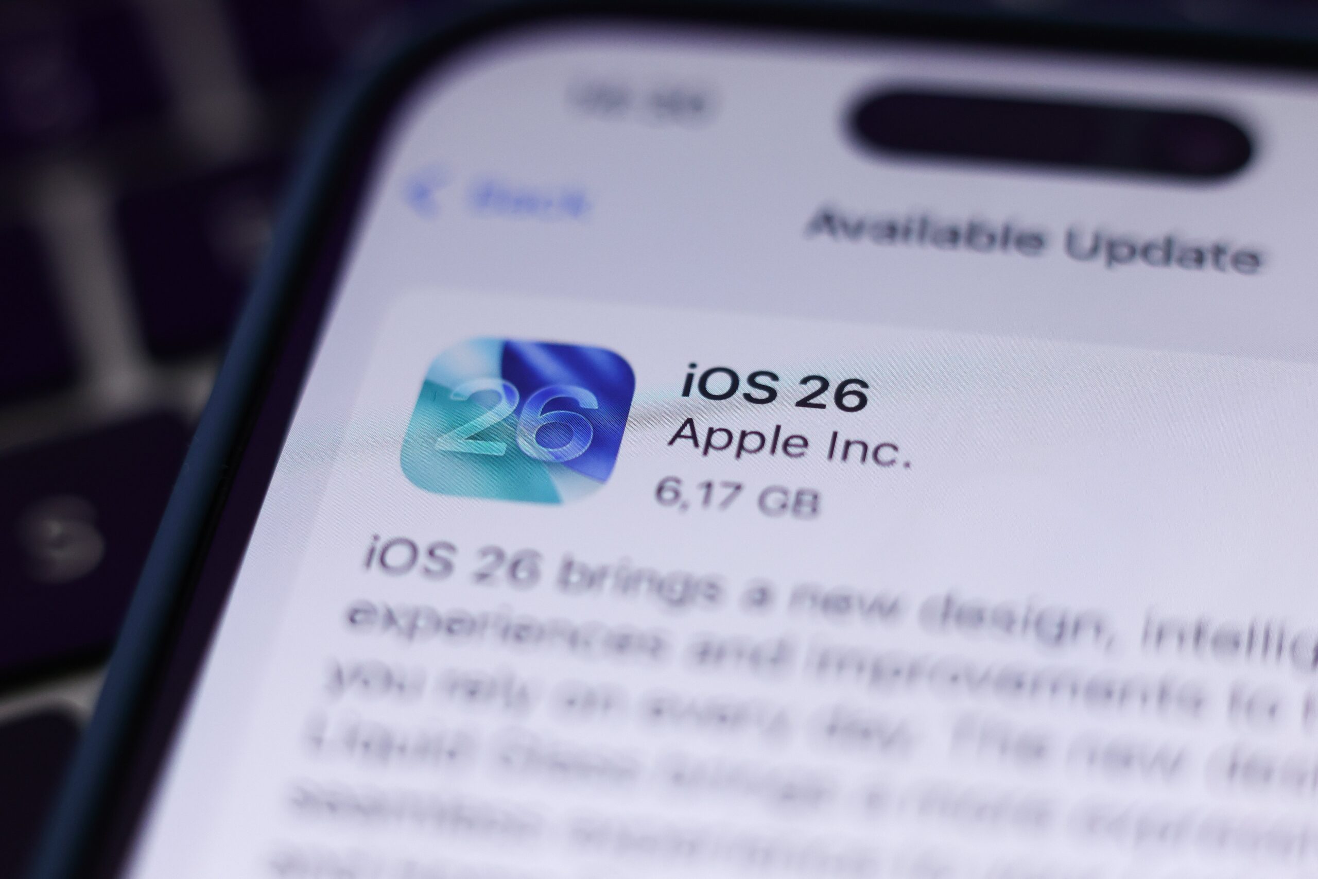 A close up photo of an iPhone showing the iOS 26 download screen in settings. 