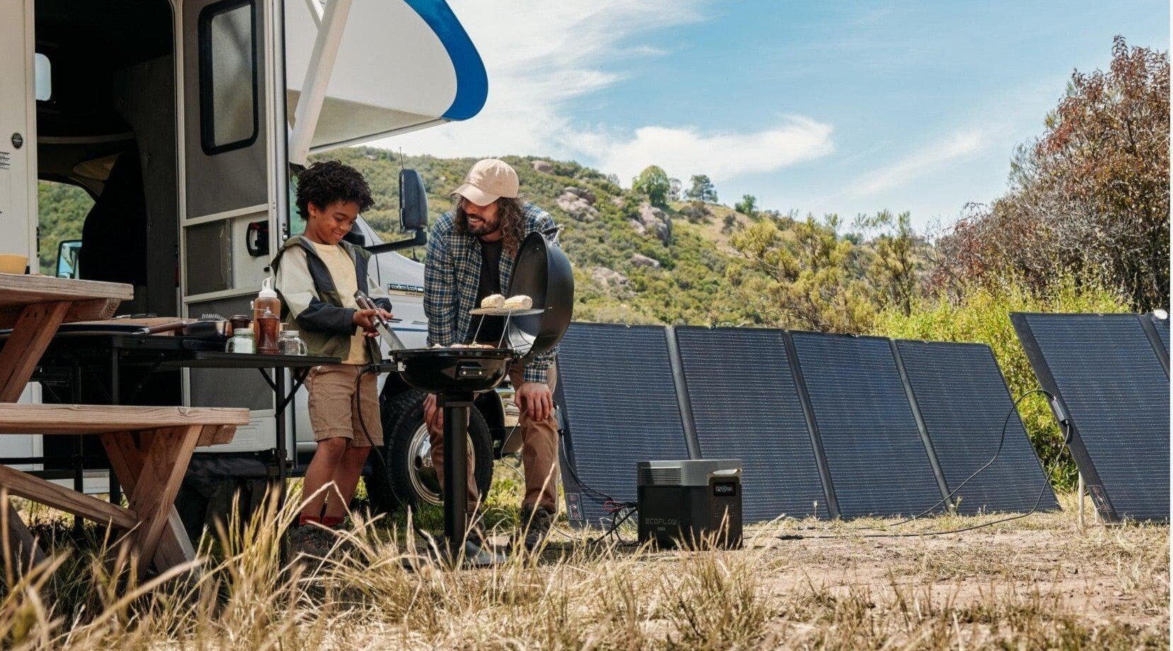 the EcoFlow Delta 2 Max portable power station at a campground in front of an RV. There are solar panels behind the EcoFlow