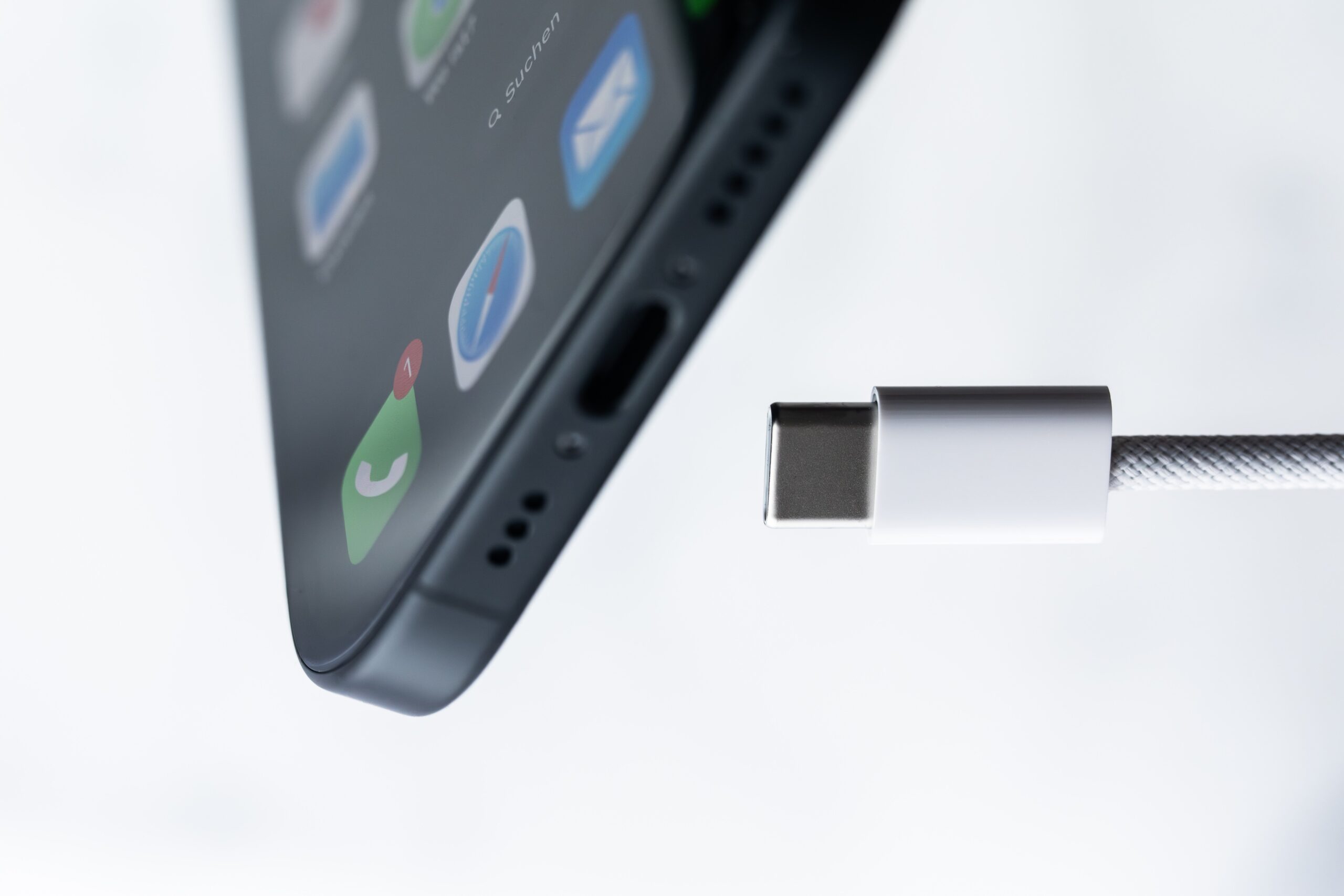 an iphone with a charging cord by it