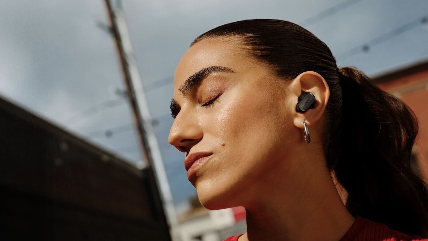 person wearing black bose qc ultra 2 earbuds