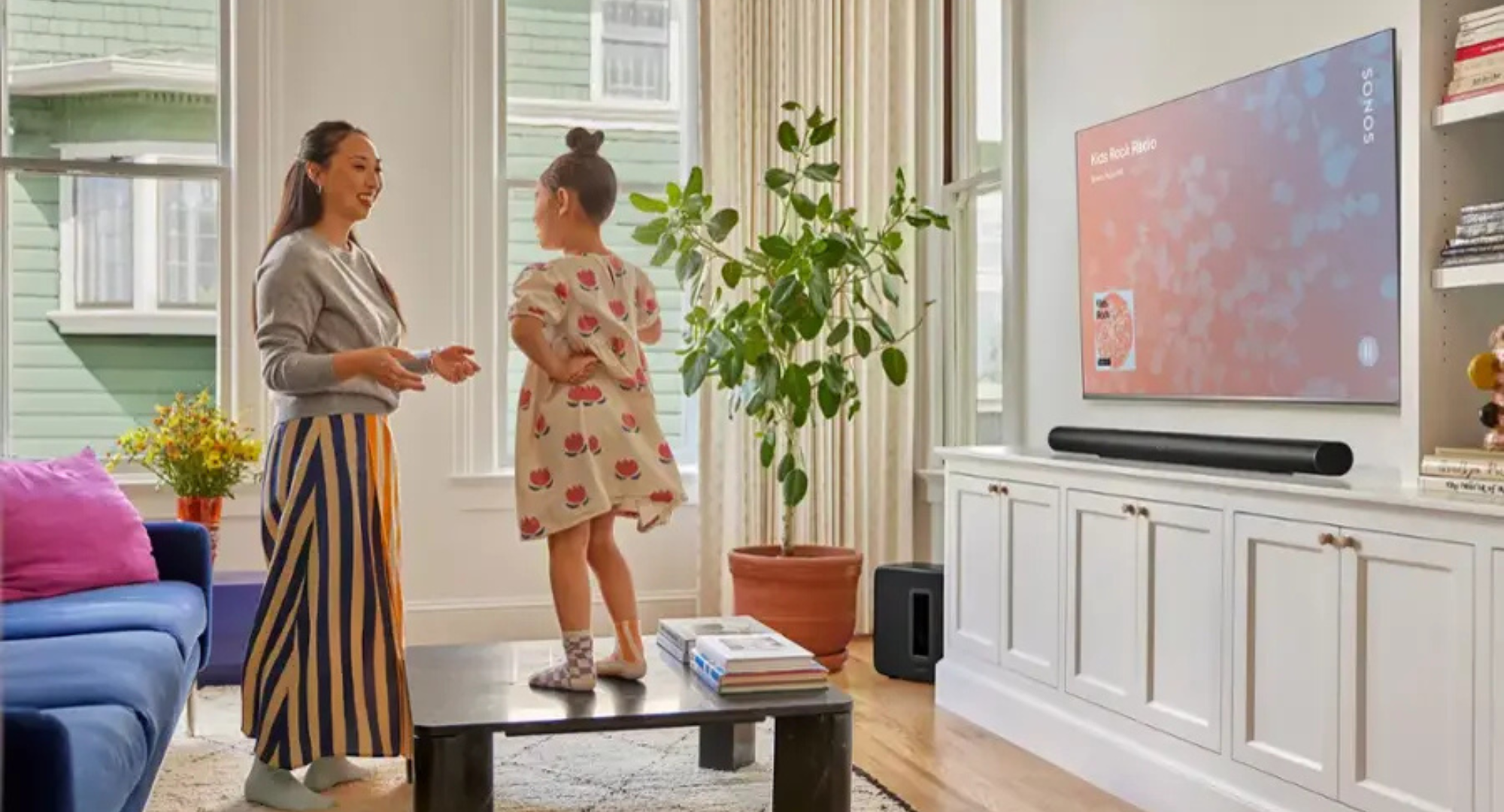 A mother and daughter talking in front of a Sonos Arc Ultra.