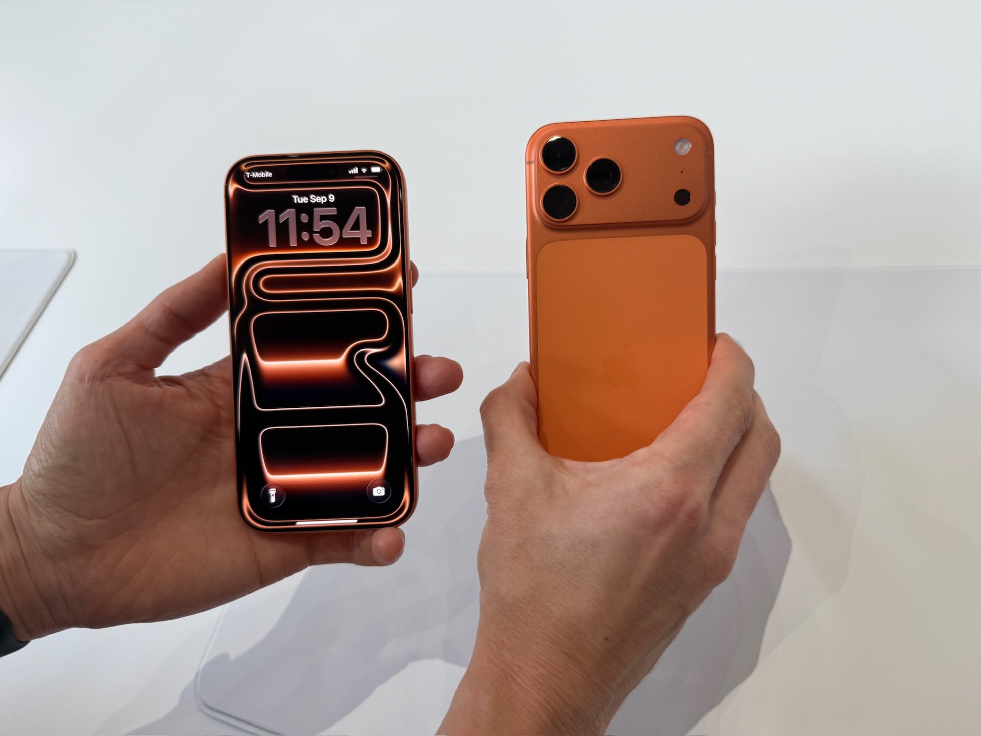 orange iphone 17 pro and pro max in hand