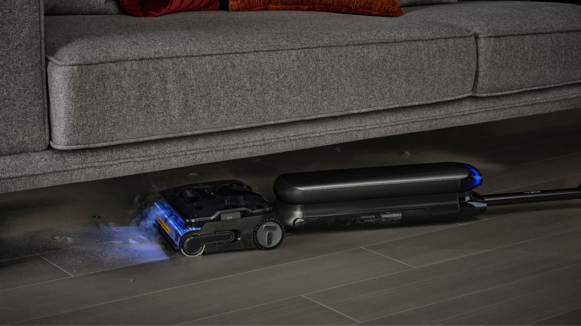 A promotional image of the Tineco S9 Artist Steam lying flat to steam under a couch.
