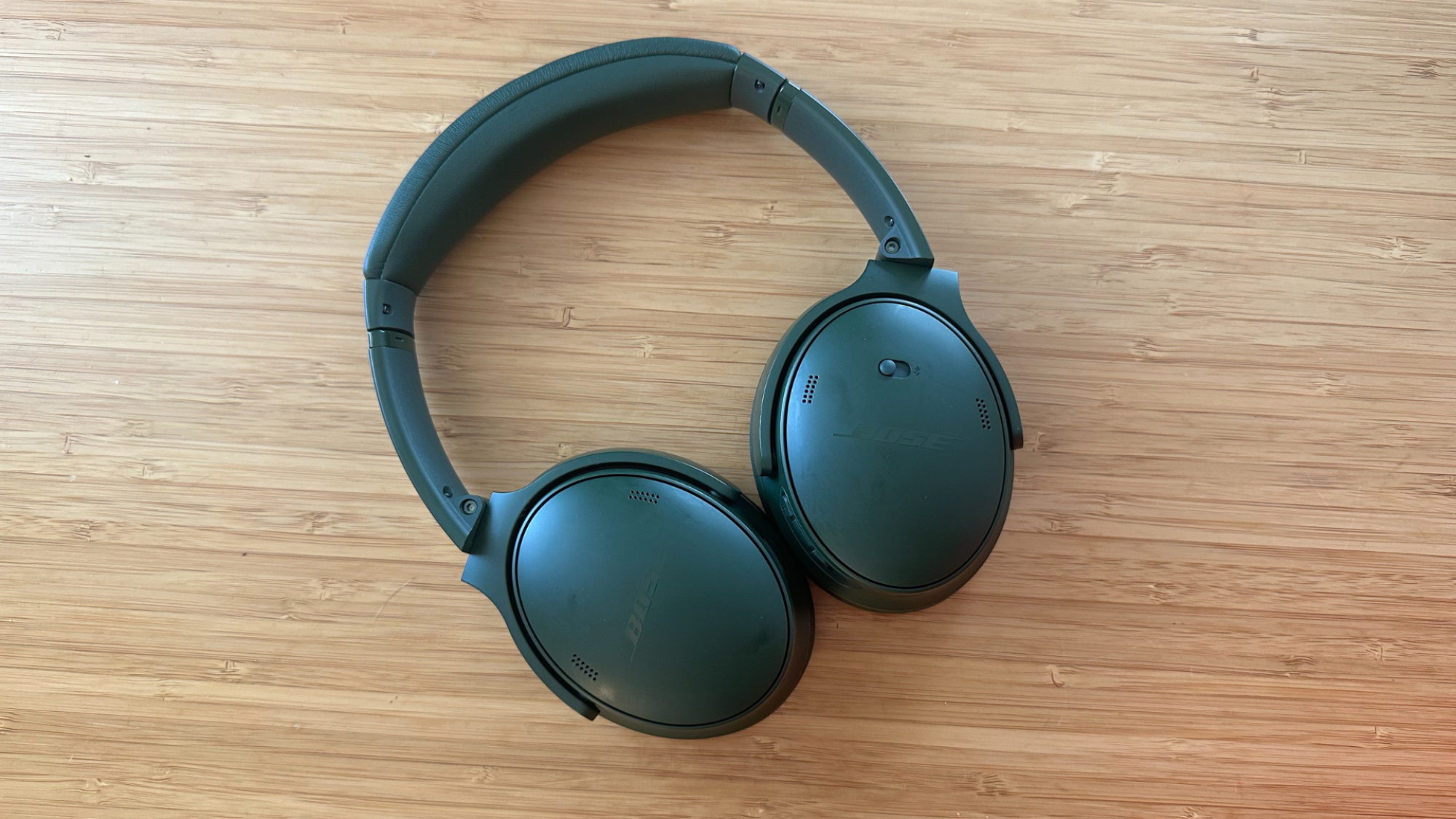 A pair of Bose QuietComfort headphones on a wooden table