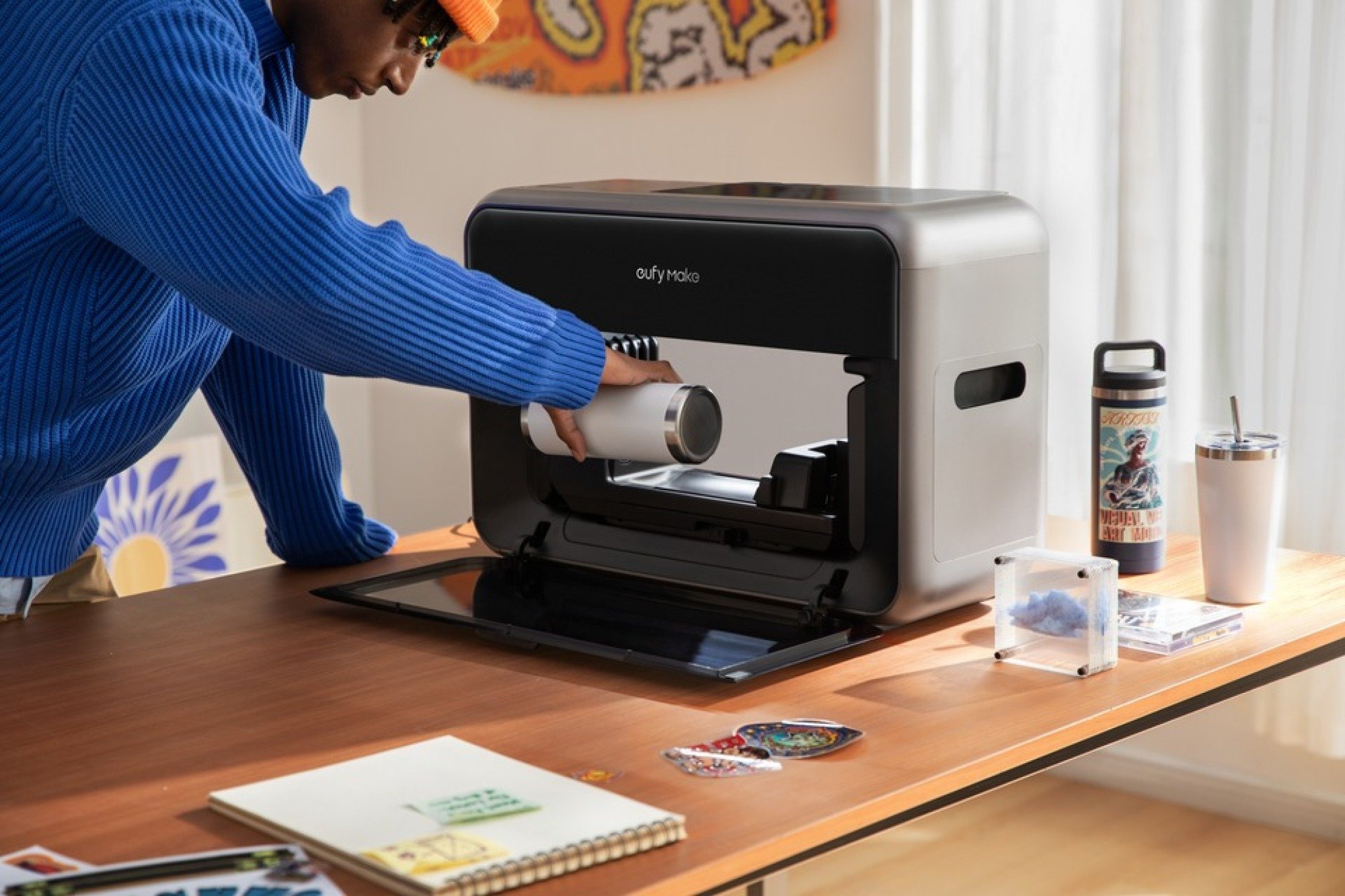 a person uses the EufyMake E1 UV Printer to create art at home.