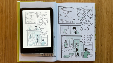 A Kindle Colorsoft laying on top of a graphic novel