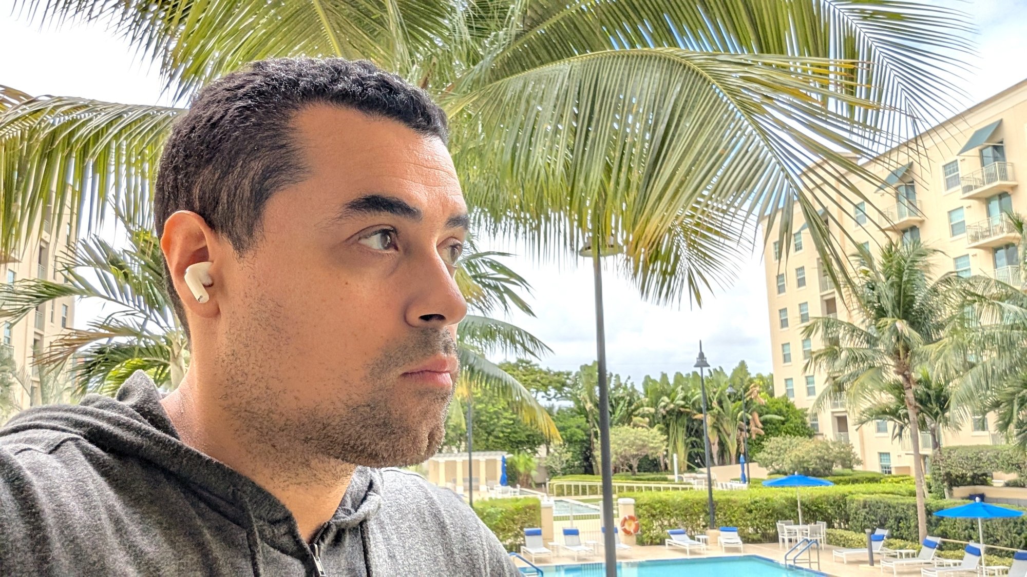 A photo of the writer sitting outside with the AirPods Pro 3 in his ears