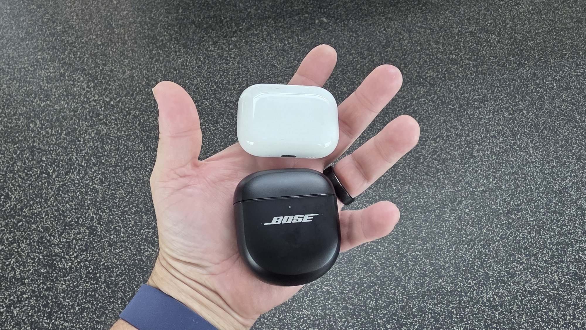 airpods pro and bose qc ultra cases in a man's hand