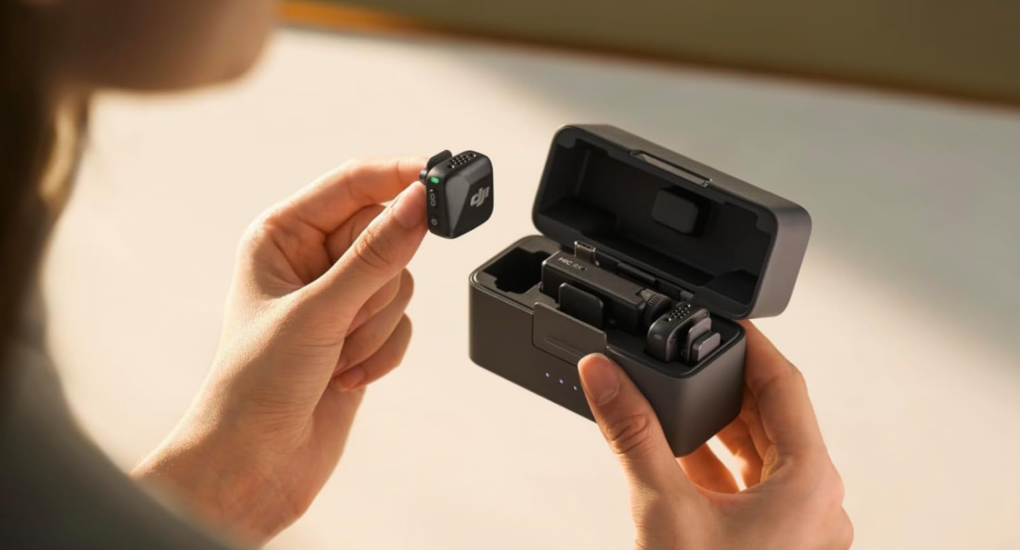 A person holding the DJI Mic Mini case and mic.