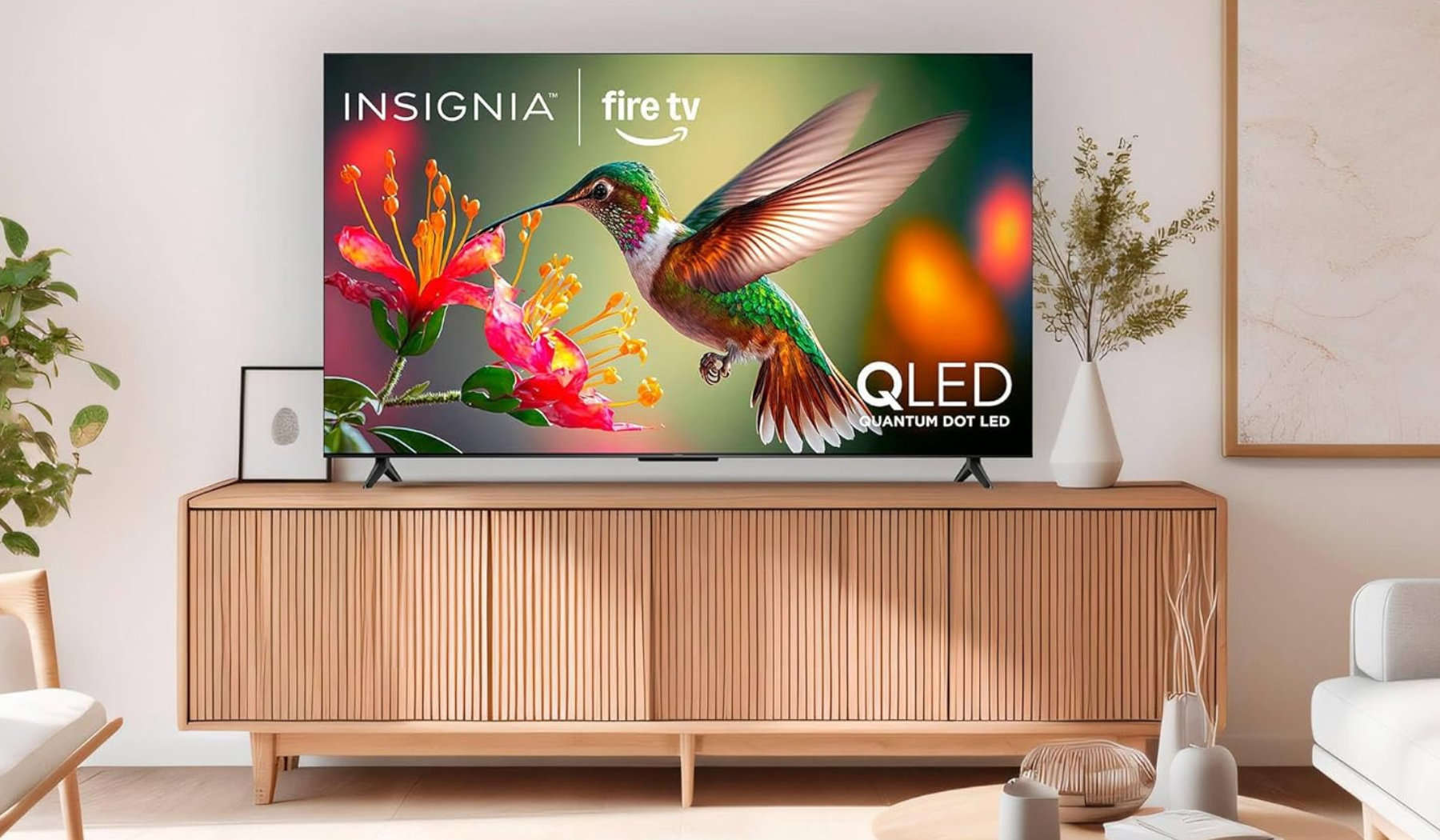 Insignia QLED TV with hummingbird screensaver on TV stand