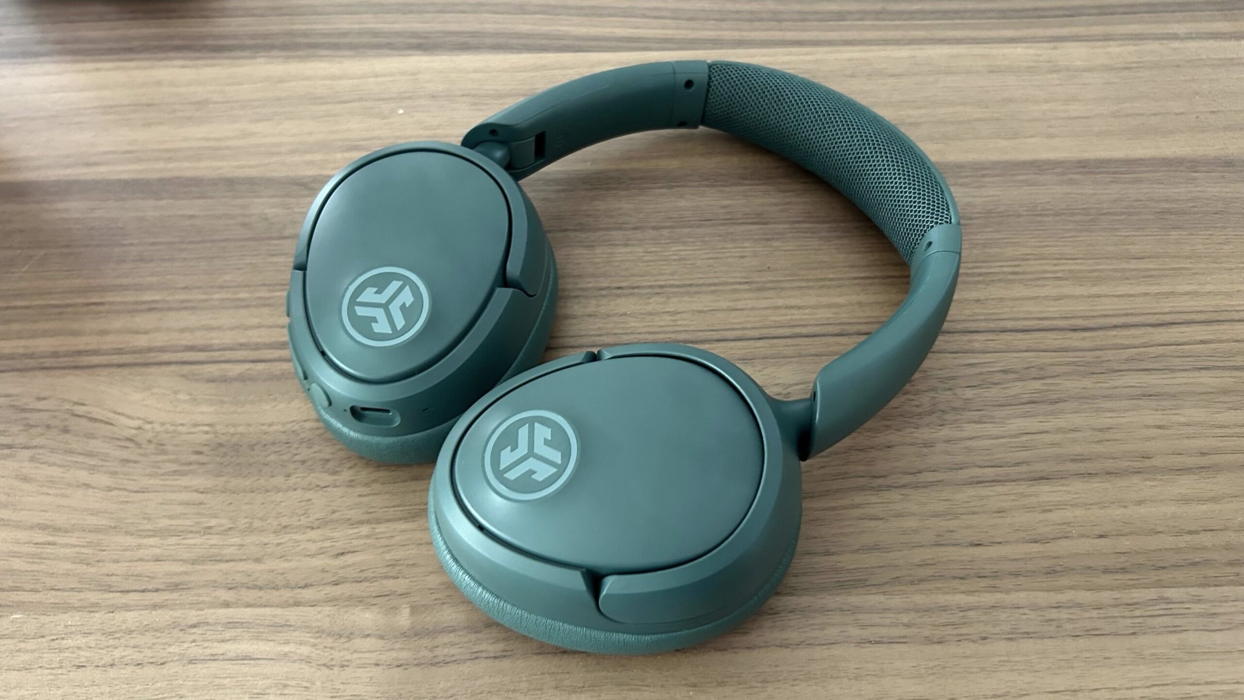 A pair of JLab JBuds Lux headphones on a table
