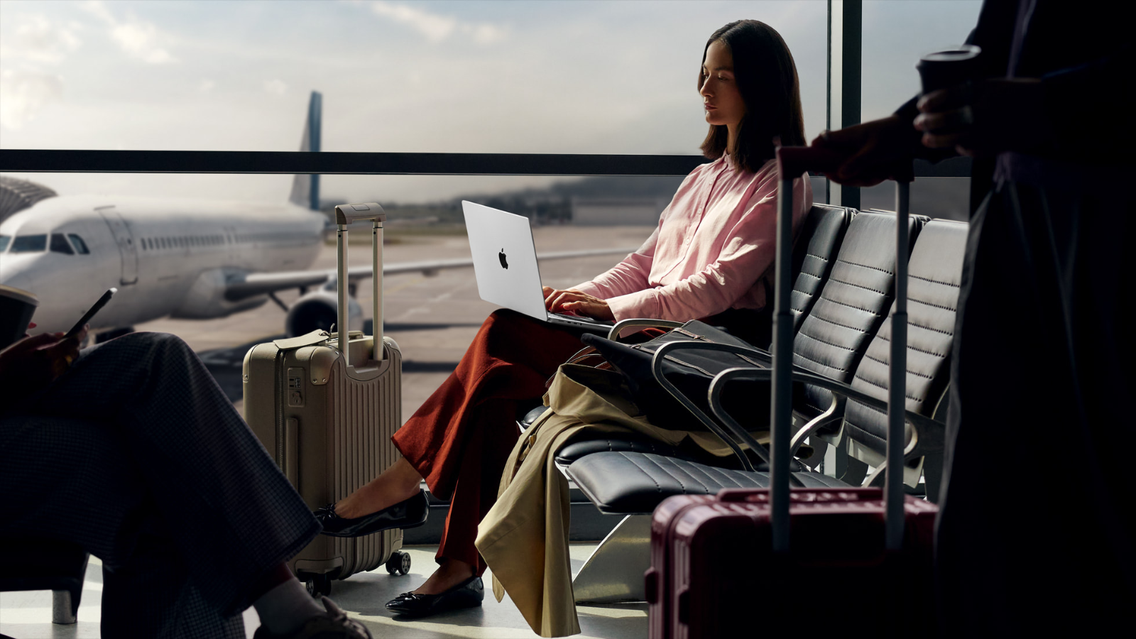 a woman working on a 14-inch m5 apple macbook pro at an airport