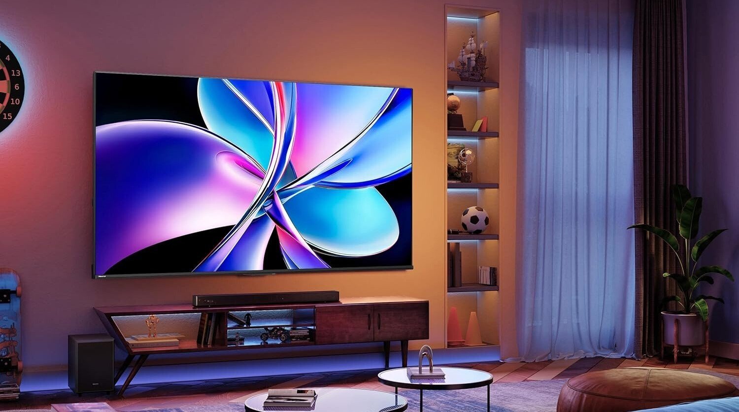 the Hisense 85-inch QD7 in a dimly lit living room. The TV displays a flower.